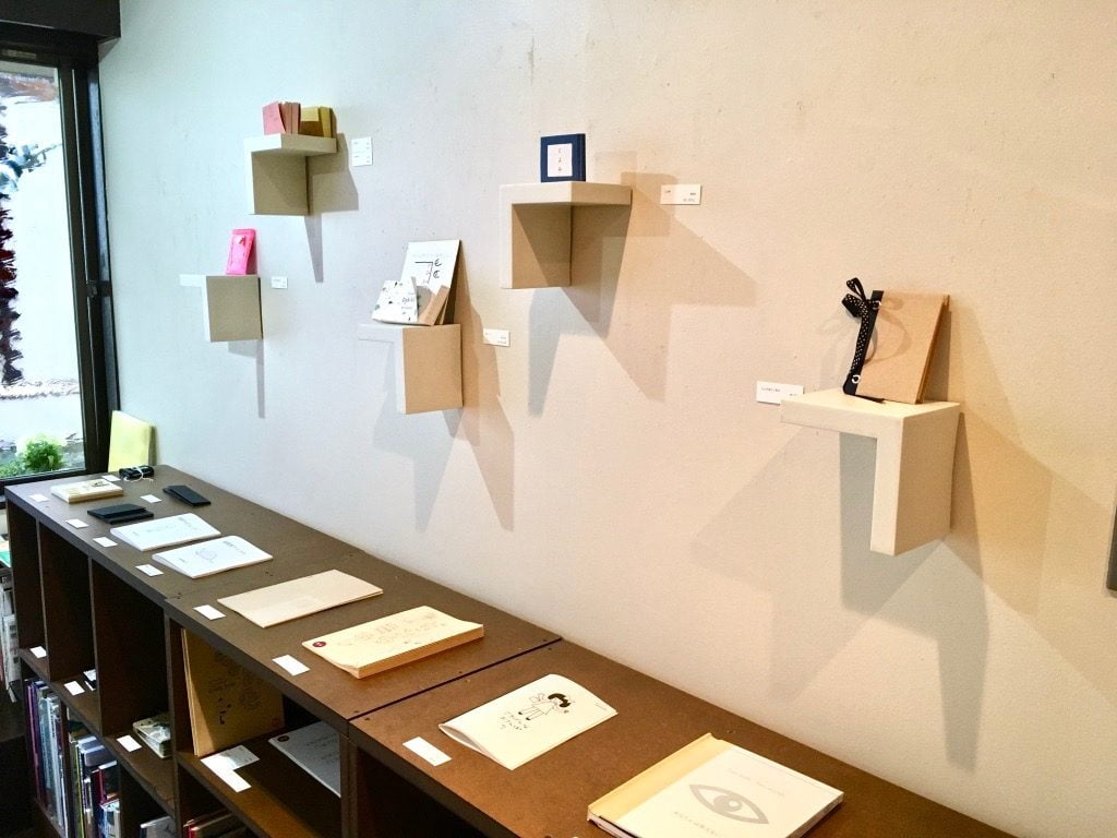 Book+の展示店の棚と内壁に飾られた本