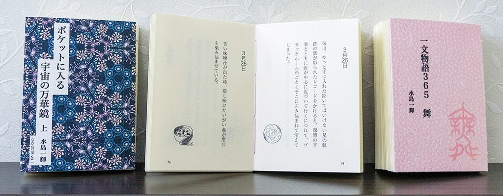 棚に飾られた手製本「ポケットに入る宇宙の万華鏡 上」「一文物語365 舞」