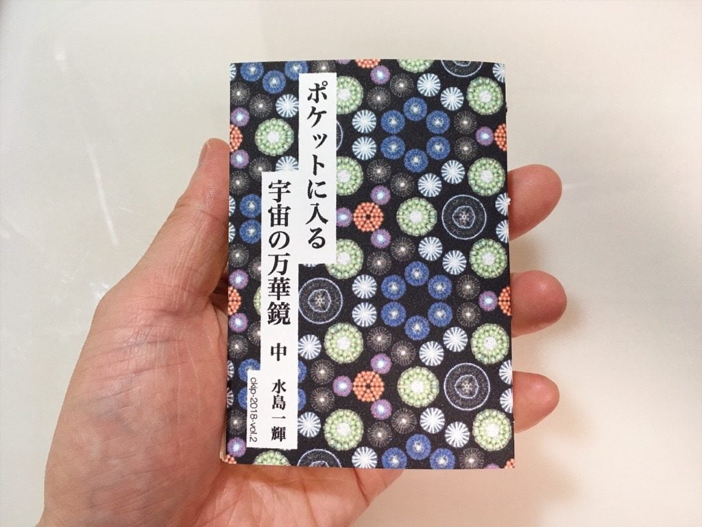 新作一文物語手製本「ポケットに入る宇宙の万華鏡 中」を手に持っているところ