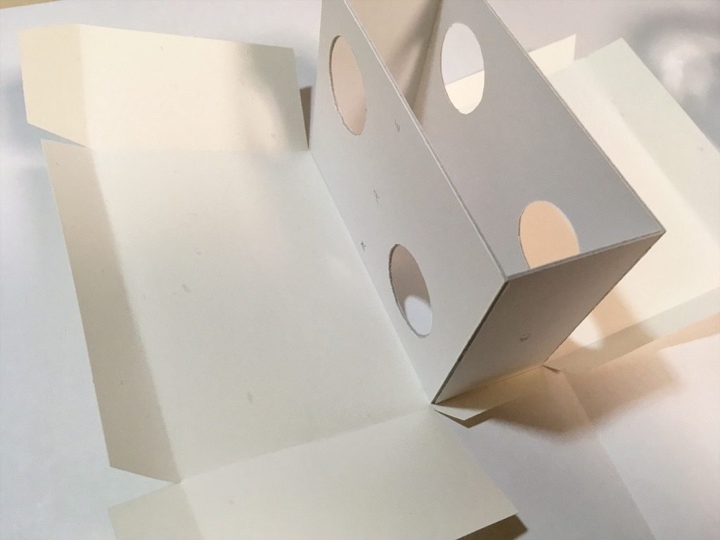 ポケットに入る宇宙の万華鏡BOXの外装を箱に貼っているところ