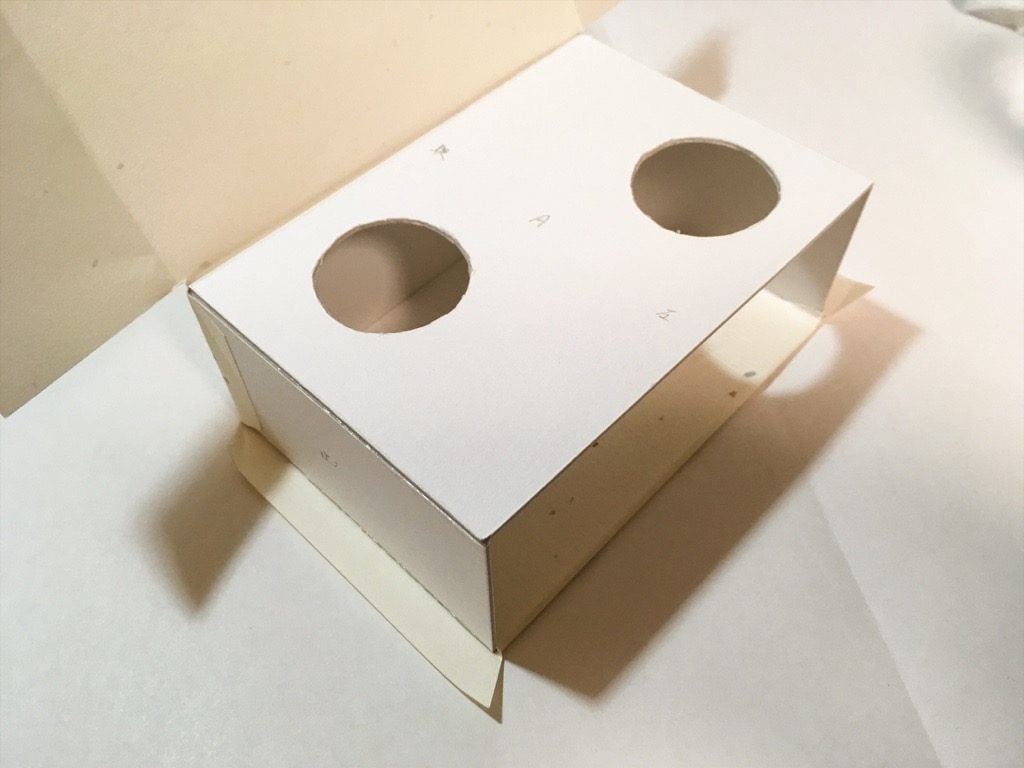 ポケットに入る宇宙の万華鏡BOXの外装を箱に貼っているところ