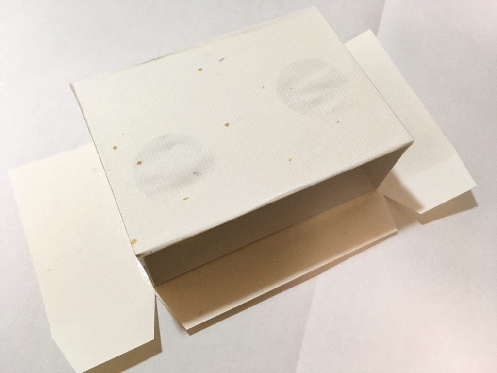 ポケットに入る宇宙の万華鏡BOXの外装を箱に貼っているところ